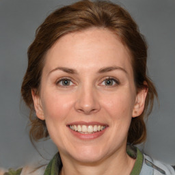 Joyful white adult female with medium  brown hair and green eyes