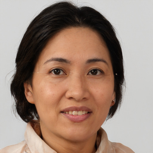 Joyful asian adult female with medium  brown hair and brown eyes