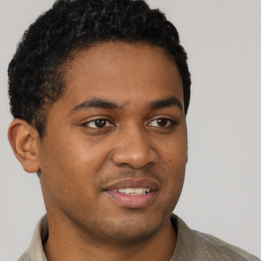 Joyful black young-adult male with short  brown hair and brown eyes
