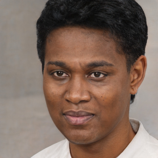 Joyful black young-adult male with short  black hair and brown eyes