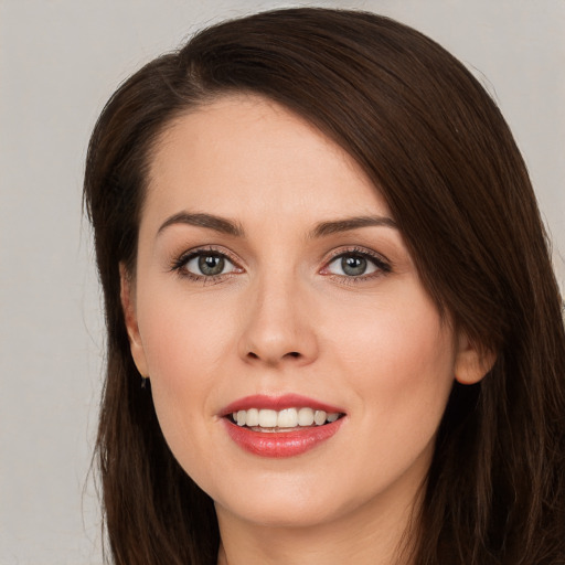 Joyful white young-adult female with long  brown hair and brown eyes