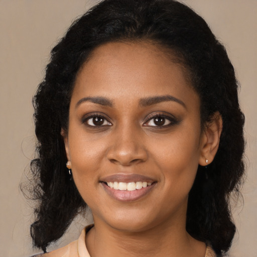 Joyful black young-adult female with long  black hair and brown eyes