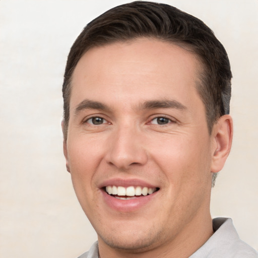 Joyful white young-adult male with short  brown hair and brown eyes