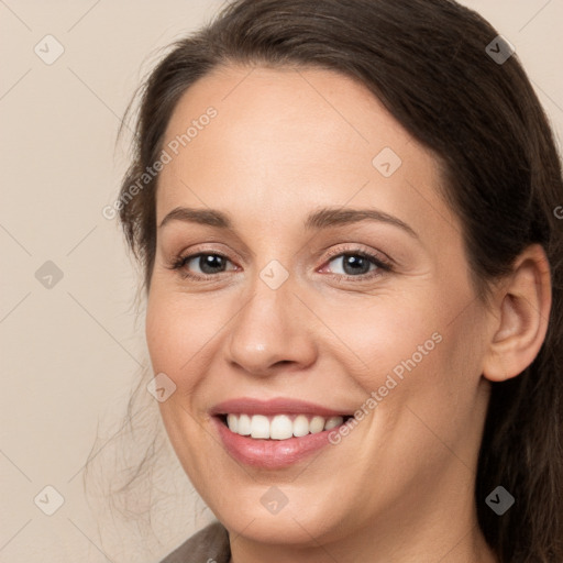 Joyful white young-adult female with long  brown hair and brown eyes