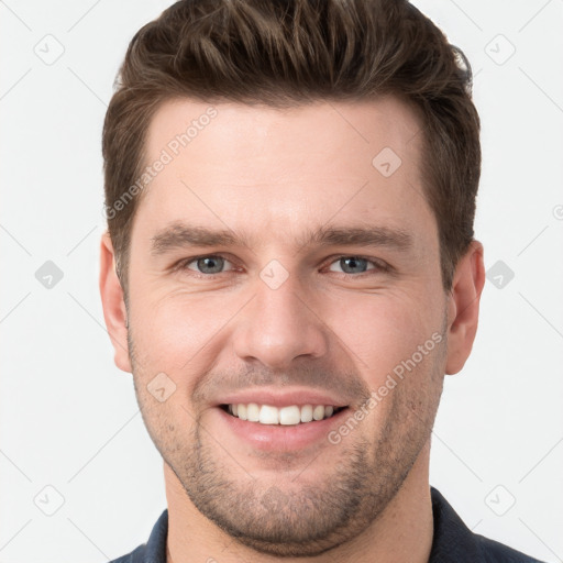 Joyful white young-adult male with short  brown hair and grey eyes