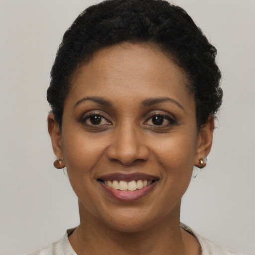 Joyful black young-adult female with short  black hair and brown eyes