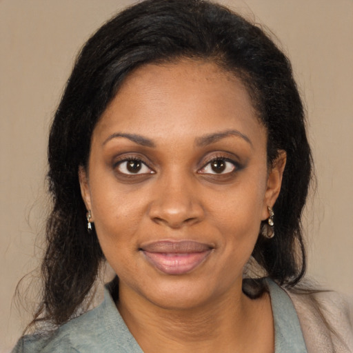 Joyful black young-adult female with long  brown hair and brown eyes