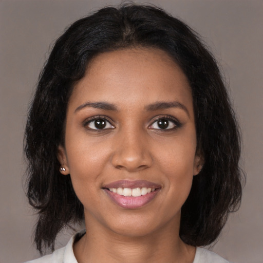 Joyful black young-adult female with medium  brown hair and brown eyes