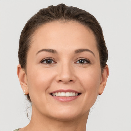 Joyful white young-adult female with short  brown hair and grey eyes