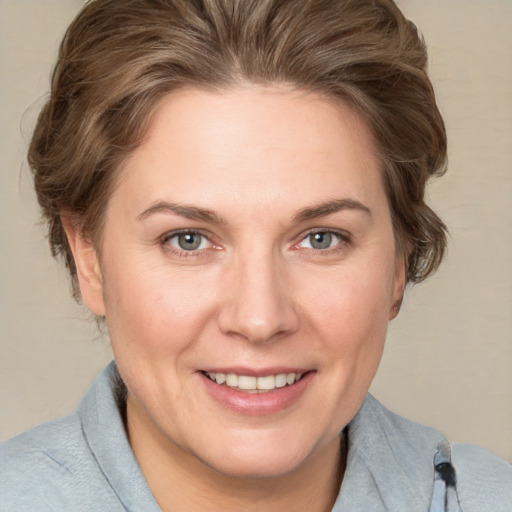 Joyful white adult female with medium  brown hair and grey eyes