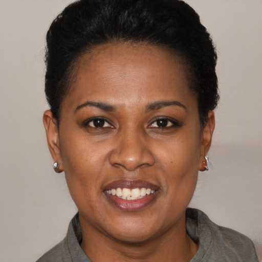 Joyful black young-adult female with short  black hair and brown eyes