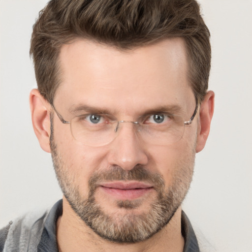 Joyful white adult male with short  brown hair and grey eyes