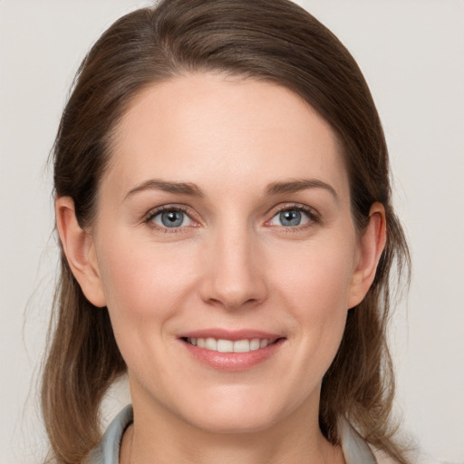 Joyful white young-adult female with medium  brown hair and grey eyes