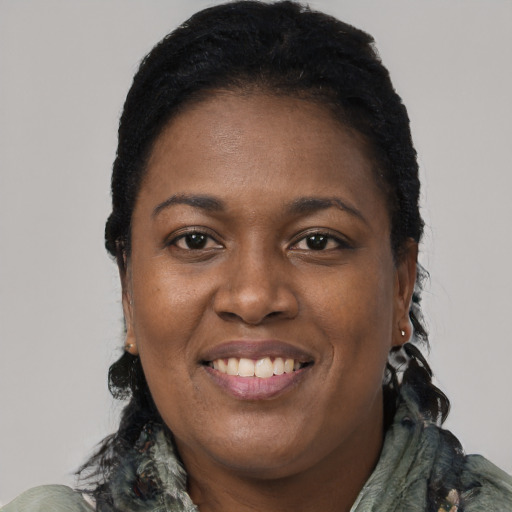 Joyful black young-adult female with long  black hair and brown eyes