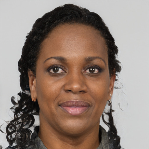 Joyful black adult female with long  brown hair and brown eyes
