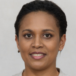 Joyful black adult female with short  brown hair and brown eyes