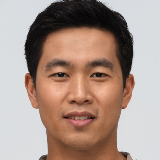 Joyful asian young-adult male with short  black hair and brown eyes