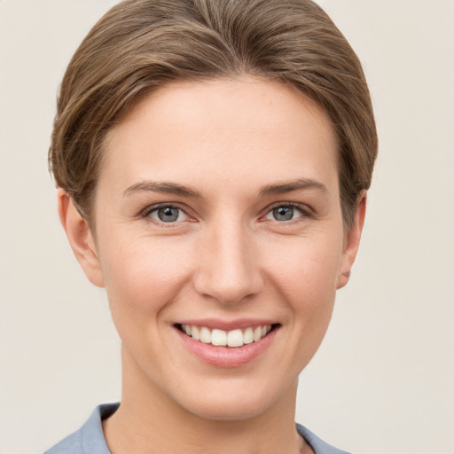 Joyful white young-adult female with short  brown hair and grey eyes