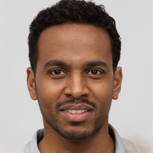 Joyful black young-adult male with short  black hair and brown eyes