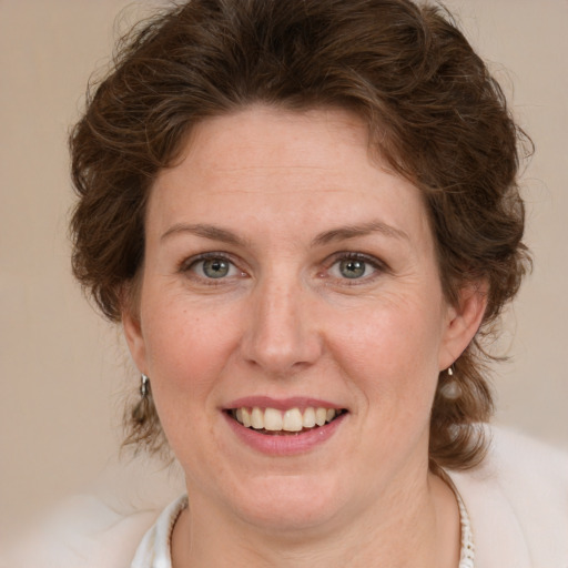 Joyful white adult female with medium  brown hair and green eyes