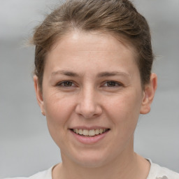 Joyful white young-adult female with short  brown hair and grey eyes