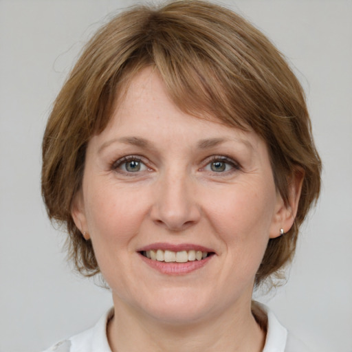 Joyful white adult female with medium  brown hair and grey eyes