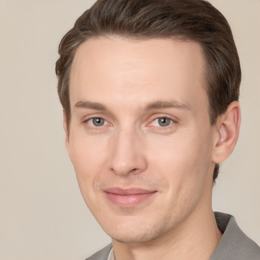 Joyful white young-adult male with short  brown hair and grey eyes