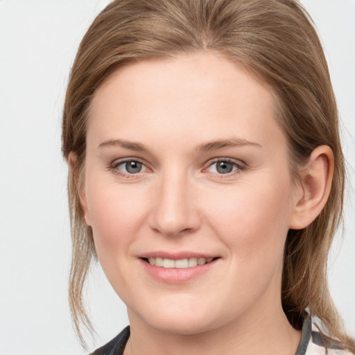 Joyful white young-adult female with medium  brown hair and grey eyes