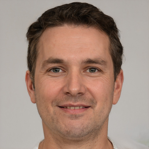 Joyful white adult male with short  brown hair and grey eyes