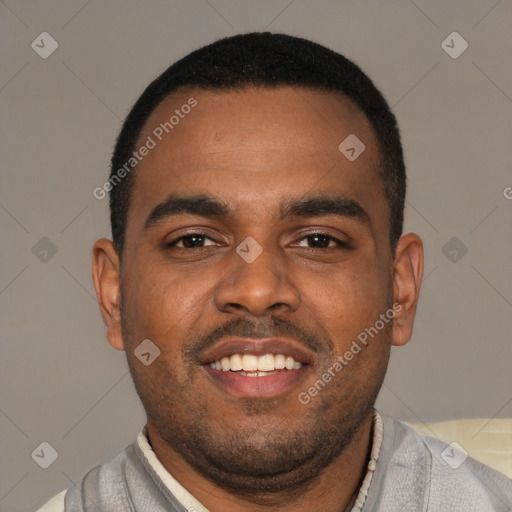 Joyful black young-adult male with short  brown hair and brown eyes
