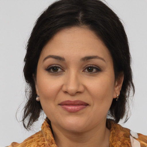 Joyful latino adult female with medium  brown hair and brown eyes