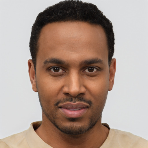 Joyful black young-adult male with short  black hair and brown eyes