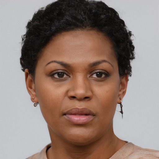Joyful black young-adult female with short  black hair and brown eyes