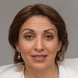 Joyful white adult female with medium  brown hair and brown eyes