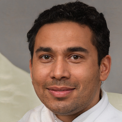 Joyful latino adult male with short  black hair and brown eyes