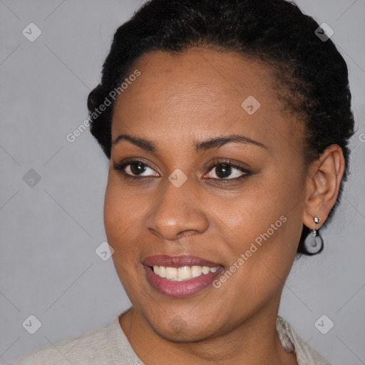 Joyful black young-adult female with short  black hair and brown eyes