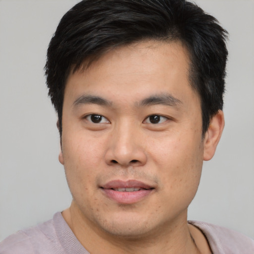 Joyful asian young-adult male with short  brown hair and brown eyes