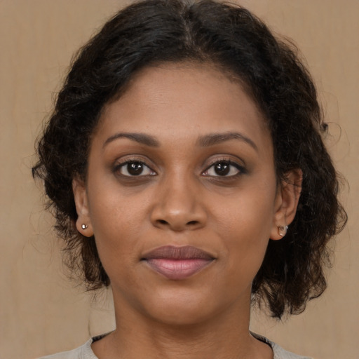 Joyful black young-adult female with medium  brown hair and brown eyes