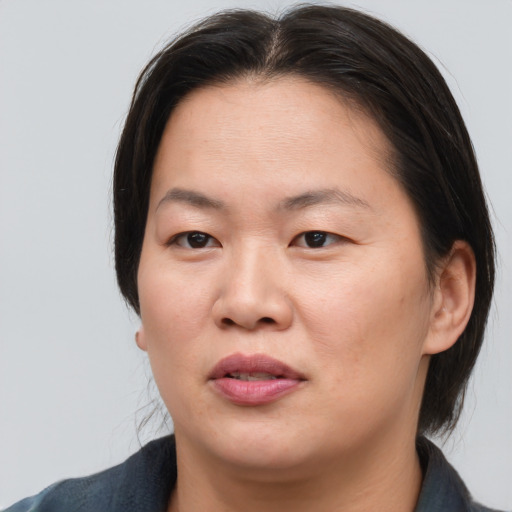 Joyful asian adult female with medium  brown hair and brown eyes