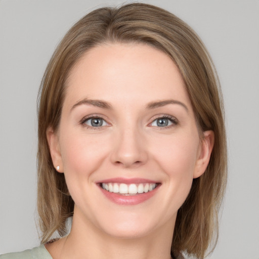 Joyful white young-adult female with medium  brown hair and grey eyes