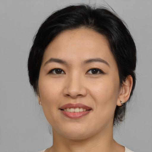 Joyful asian adult female with medium  brown hair and brown eyes