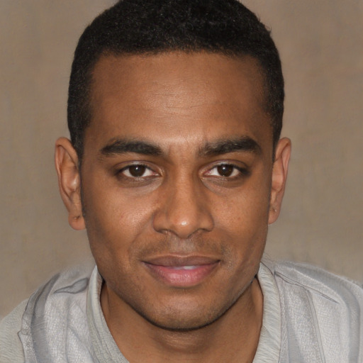 Joyful black young-adult male with short  brown hair and brown eyes
