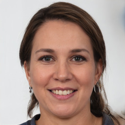 Joyful white adult female with medium  brown hair and grey eyes