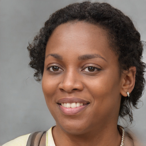 Joyful black young-adult female with medium  brown hair and brown eyes