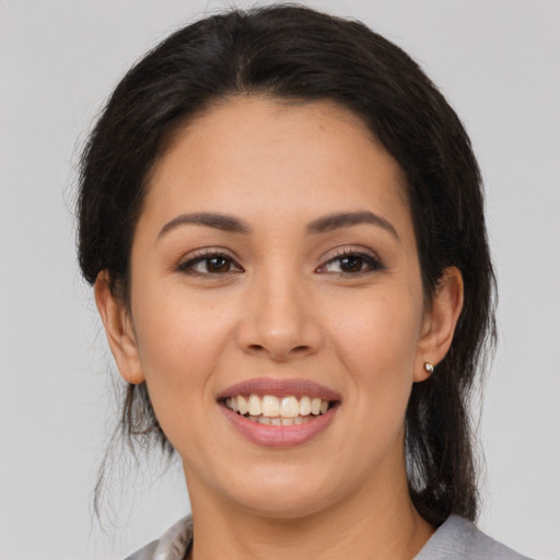 Joyful latino young-adult female with medium  brown hair and brown eyes