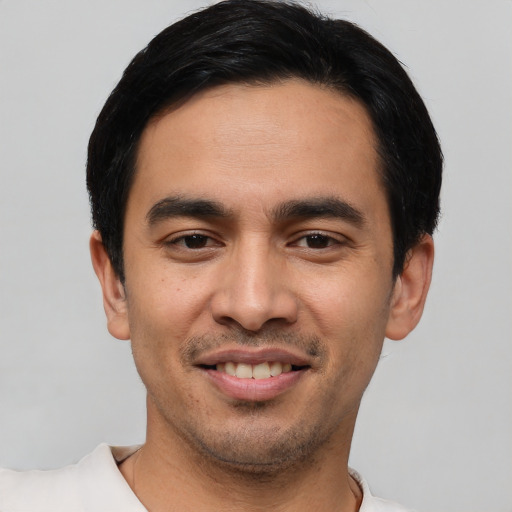 Joyful white young-adult male with short  black hair and brown eyes