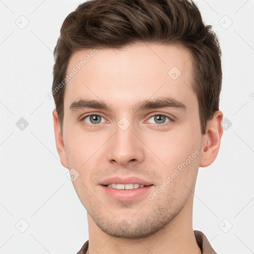 Joyful white young-adult male with short  brown hair and grey eyes