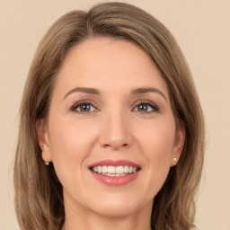 Joyful white young-adult female with long  brown hair and green eyes