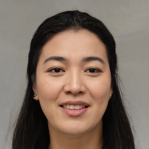 Joyful asian young-adult female with long  black hair and brown eyes