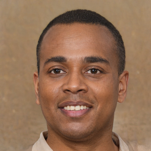Joyful latino young-adult male with short  brown hair and brown eyes